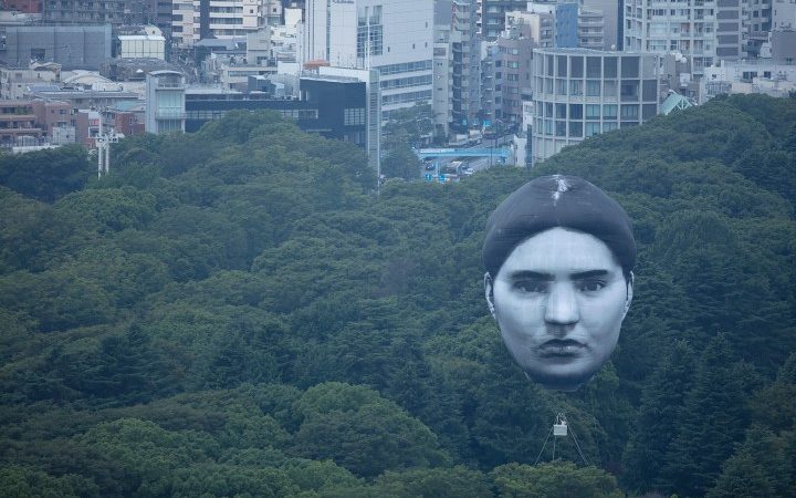 Gigantisch ballongezicht zweeft boven Tokio
