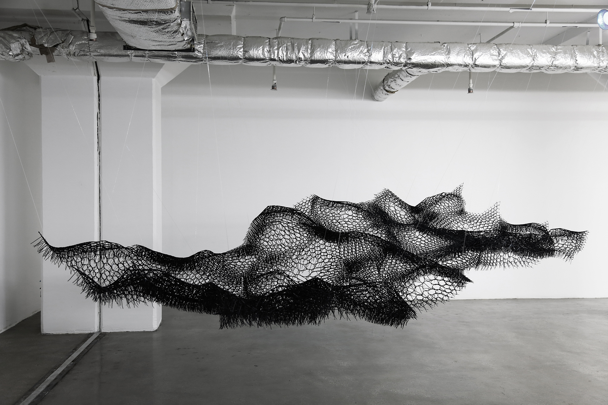 In elkaar grijpende kabelbinders vormen golvend water en biomorfe sculpturen van Sui Park