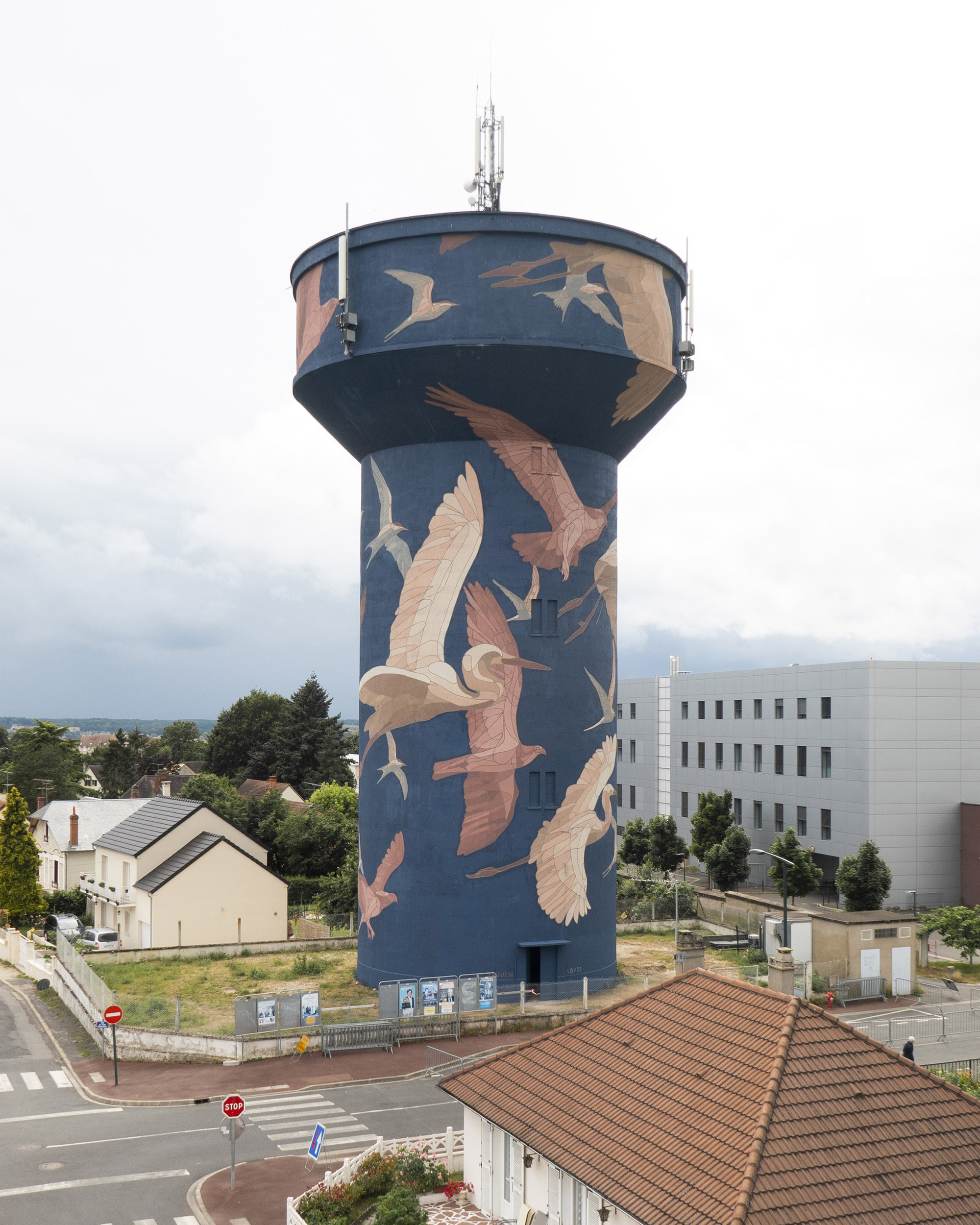 Vliegende visarenden, reigers en sterns omvatten een 35 meter lange watertoren-muurschildering door Taquen